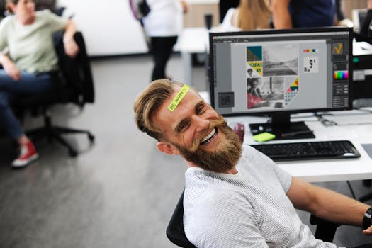Man at desk smiling as he is happy in his work environment