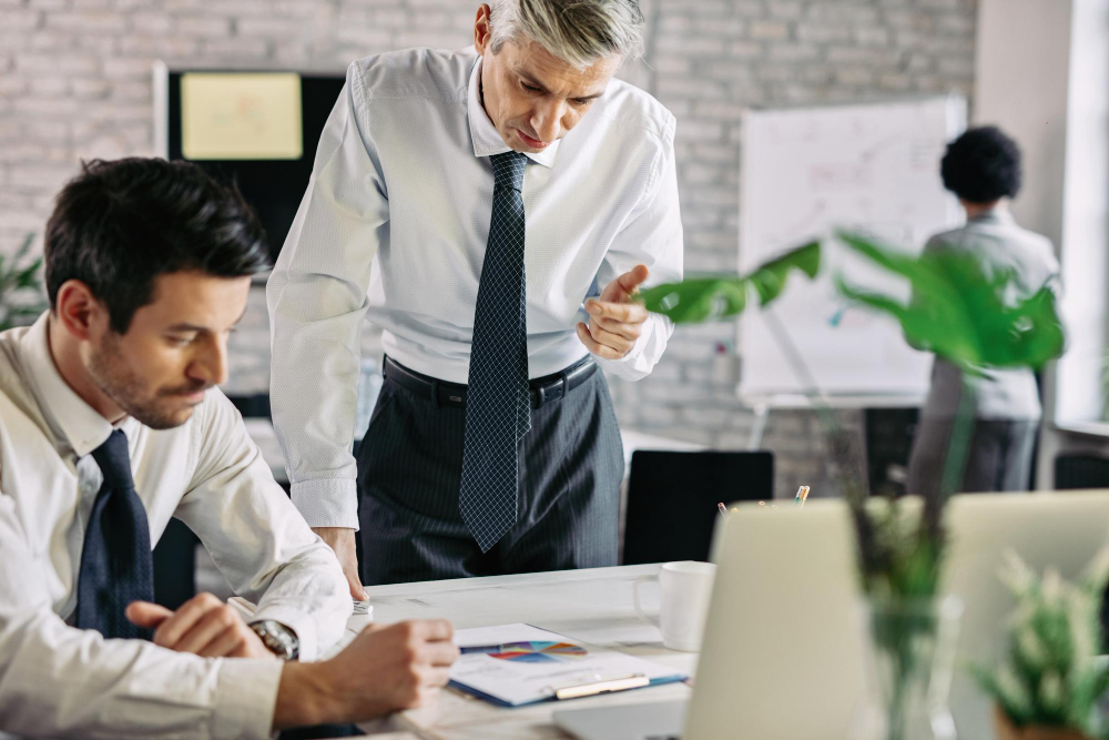 mid adult businessman going through paperwork reading project statistics while working office